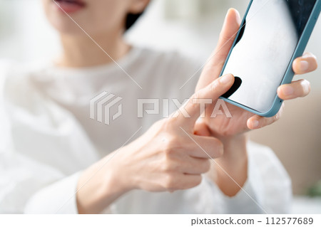 Angry woman holding a smartphone Angry woman holding a smartphone 112577689