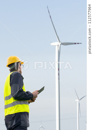 Engineer with tablet computer on a background of wind turbines Engineer with tablet computer on a background of wind turbines 112577964