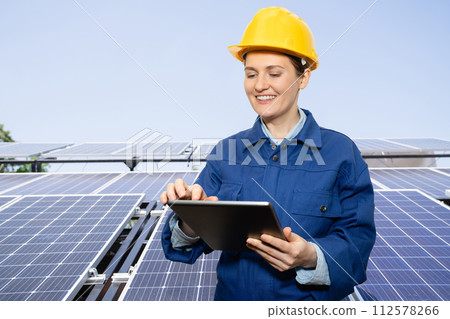 Woman with digital tablet on a background of mobile solar power station.. 112578266