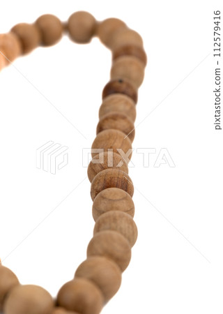 Selective focus on grains of rosary over a white background. 112579416