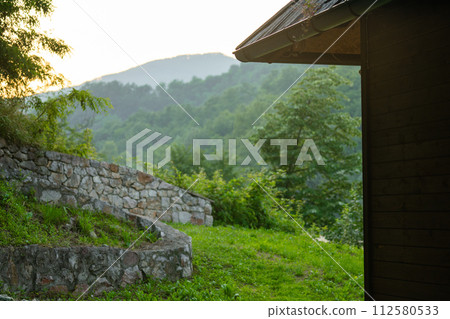 Porch of a wooden house in the forest on the river bank Porch of a wooden house in the forest on the river bank 112580533