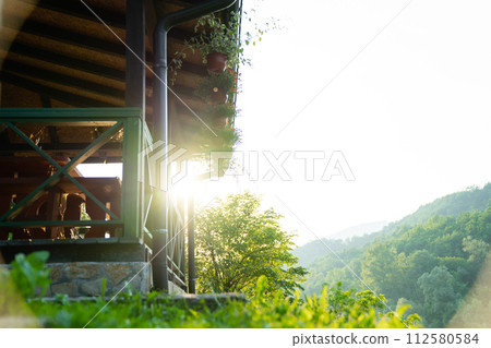 Porch of a wooden house in the forest on the river bank 112580584