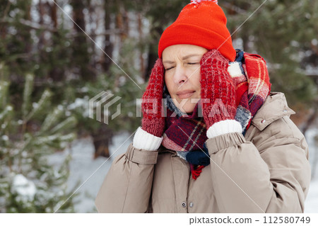 Waist up of a woman in red having headache 112580749