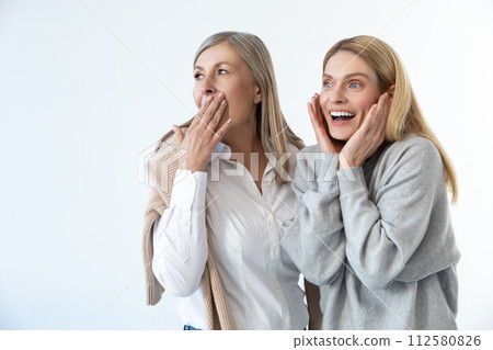 Two women discussing something and looking impressed 112580826