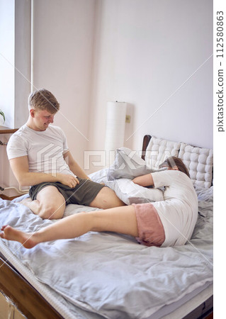 young couple on the bed playing and fighting young couple on the bed playing and fighting 112580863
