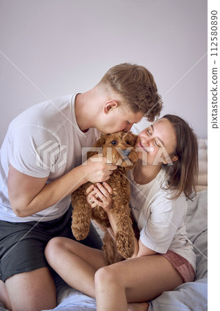 a couple gently hugs and kisses a cockapoo girl, minimalism a couple gently hugs and kisses a cockapoo girl, minimalism 112580890