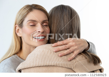Blonde woman hugging her mom and looking happy 112580923