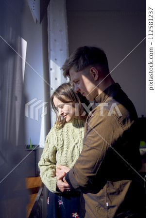 beautiful young couple kissing near the window beautiful young couple kissing near the window 112581237