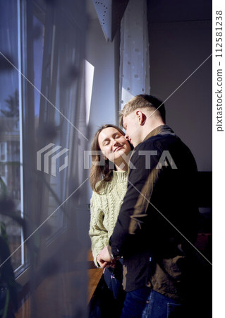 beautiful young couple kissing near the window 112581238