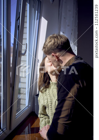 beautiful young couple kissing near the window beautiful young couple kissing near the window 112581239