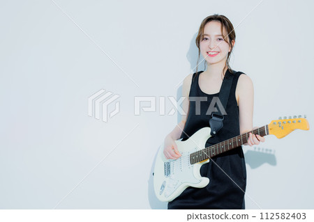A woman playing an electric guitar A woman playing an electric guitar 112582403