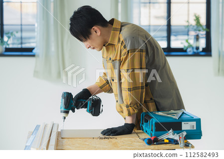 A young man working with an electric screwdriver 112582493