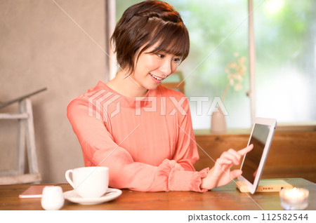 A woman choosing a menu at a cafe A woman choosing a menu at a cafe 112582544