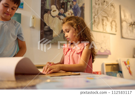 Portrait of an authentic schoolgirl learning painting in the art class in visual art gallery or creative art school Portrait of an authentic schoolgirl learning painting in the art class in visual art gallery or creative art school 112583117