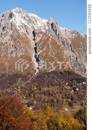 Beautiful landscape of the layered misty hazy Italian Alps mountain range during evening. Lombardy, Italy 112583456