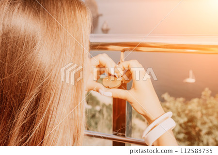 Hands, lock, heart, love, valentines day. Close-up of a woman's hands holding heart shaped padlock with a heart. The concept of Valentine's day, wedding, symbol of love and fidelity. 112583735