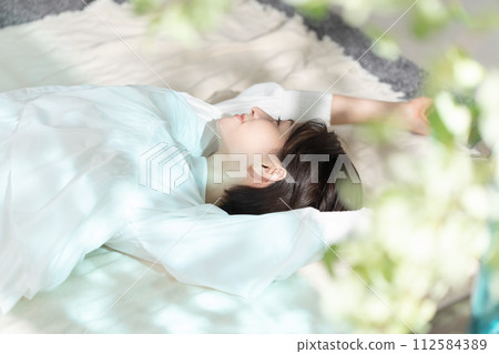 一個女人在陽光下打盹 112584389