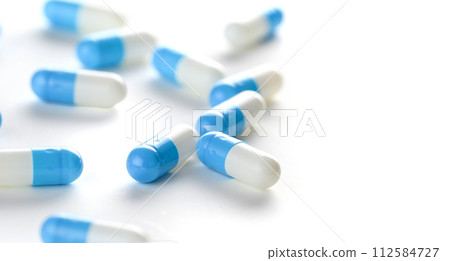 Blue white capsules on white background. Blue white capsules on white background. 112584727