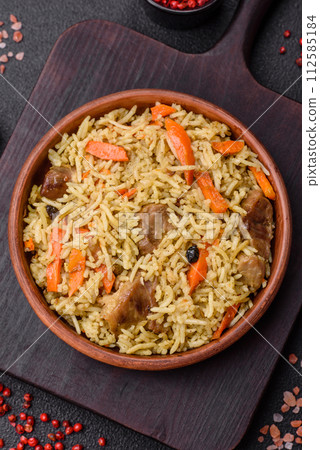 Delicious pilaf with vegetables, salt, spices and herbs in a ceramic plate Delicious pilaf with vegetables, salt, spices and herbs in a ceramic plate 112585184