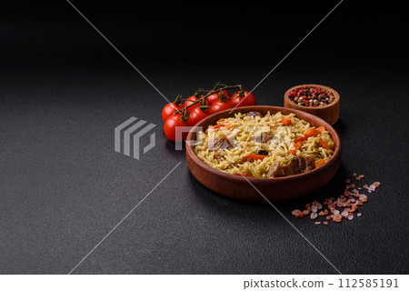 Delicious pilaf with vegetables, salt, spices and herbs in a ceramic plate 112585191