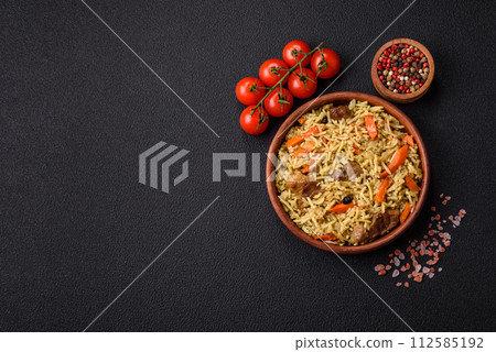 Delicious pilaf with vegetables, salt, spices and herbs in a ceramic plate 112585192