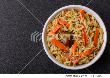 Delicious pilaf with vegetables, salt, spices and herbs in a ceramic plate 112585198