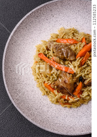 Delicious pilaf with vegetables, salt, spices and herbs in a ceramic plate Delicious pilaf with vegetables, salt, spices and herbs in a ceramic plate 112585233