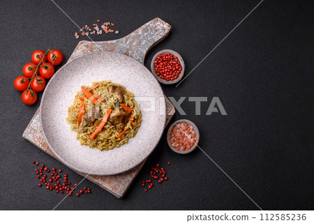 Delicious pilaf with vegetables, salt, spices and herbs in a ceramic plate 112585236