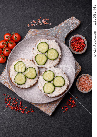 Delicious vegetarian sandwich with grilled toast, cream cheese, cucumbers and seeds Delicious vegetarian sandwich with grilled toast, cream cheese, cucumbers and seeds 112585445