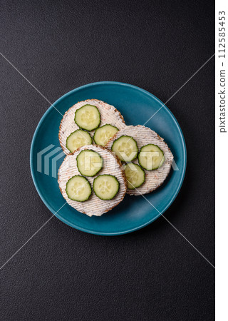 Delicious vegetarian sandwich with grilled toast, cream cheese, cucumbers and seeds 112585453