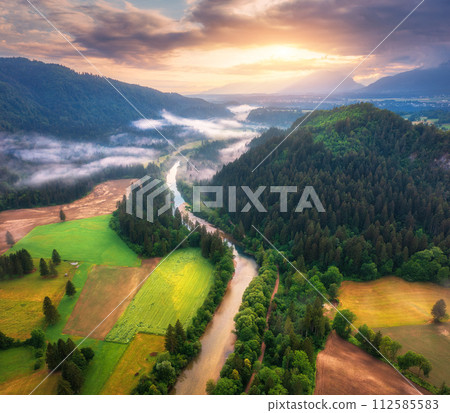 Aerial view of river in low clouds at sunrise in summer Aerial view of river in low clouds at sunrise in summer 112585583