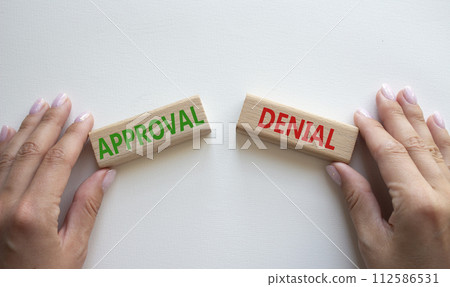 Approval or Denial symbol. Concept word Approval or Denial on wooden blocks. Businessman hand. Beautiful white background. Business and Approval or Denial concept. Copy space 112586531