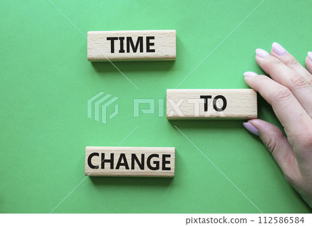 Time to change symbol. Concept word Time to change on wooden blocks. Businessman hand. Beautiful green background. Business and Time to change concept. Copy space Time to change symbol. Concept word Time to change on wooden blocks. Businessman hand. Beautiful green background. Business and Time to change concept. Copy space 112586584