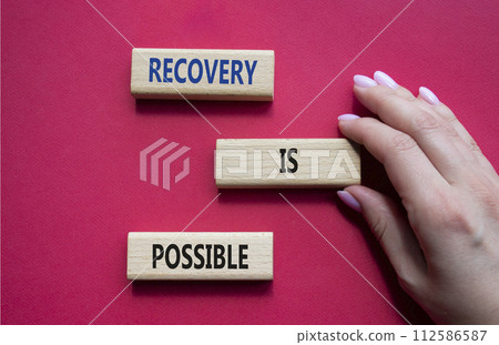 Recovery is possible symbol. Concept words Recovery is possible on wooden blocks. Beautiful red background. Businessman hand. Business and Recovery is possible concept. Copy space. Recovery is possible symbol. Concept words Recovery is possible on wooden blocks. Beautiful red background. Businessman hand. Business and Recovery is possible concept. Copy space. 112586587