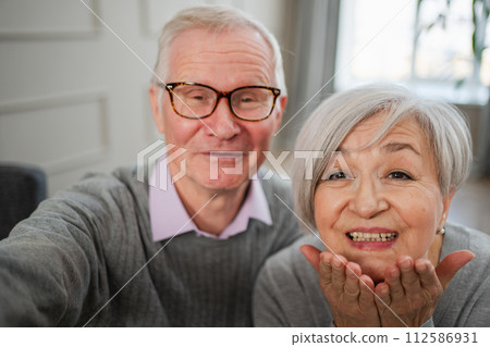 Happy senior woman man talk on video call with friends family. Mature old grandmother grandfather talking speaking with grown up children online. Older generation modern tech usage. Webcamera view Happy senior woman man talk on video call with friends family. Mature old grandmother grandfather talking speaking with grown up children online. Older generation modern tech usage. Webcamera view 112586931