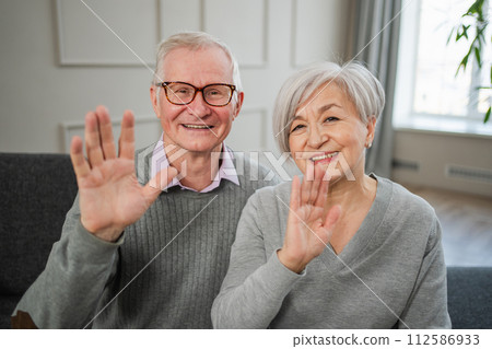 Happy senior woman man talk on video call with friends family. Mature old grandmother grandfather talking speaking with grown up children online. Older generation modern tech usage. Webcamera view Happy senior woman man talk on video call with friends family. Mature old grandmother grandfather talking speaking with grown up children online. Older generation modern tech usage. Webcamera view 112586933