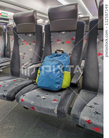A backpack on a armchair on the train. A backpack on a armchair on the train. 112587149