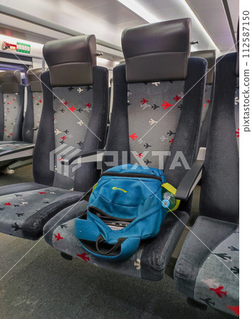 The backpack lies on the seat on the train. The backpack lies on the seat on the train. 112587150