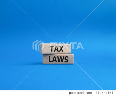 Tax Laws symbol. Concept word Tax Laws on wooden blocks. Beautiful blue background. Business and Tax Laws concept. Copy space Tax Laws symbol. Concept word Tax Laws on wooden blocks. Beautiful blue background. Business and Tax Laws concept. Copy space 112587161