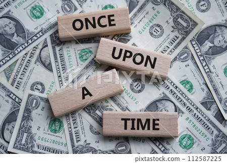 Once upon a time symbol. Concept words. Once upon a time on wooden blocks. Beautiful dollar background. Business and Once upon a time concept. Copy space Once upon a time symbol. Concept words. Once upon a time on wooden blocks. Beautiful dollar background. Business and Once upon a time concept. Copy space 112587225