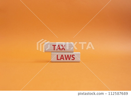 Tax Laws symbol. Concept word Tax Laws on wooden blocks. Beautiful orange background. Business and Tax Laws concept. Copy space 112587689