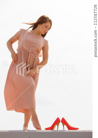 Woman dancing wearing long light pink dress Woman dancing wearing long light pink dress 112587726
