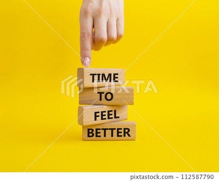Time to feel better symbol. Wooden blocks with words Time to feel better. Businessman hand. Beautiful yellow background. Medicine and Time to feel better concept. Copy space. Time to feel better symbol. Wooden blocks with words Time to feel better. Businessman hand. Beautiful yellow background. Medicine and Time to feel better concept. Copy space. 112587790