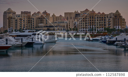 Porto Arabia Marina in The pearl, Doha, Qatar  showing luxurious yachts and boats docked at the marina with  residential buildings in background. 112587898