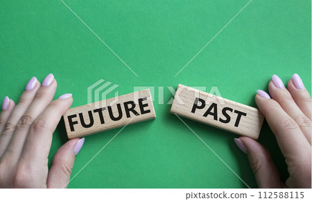 Future or Past symbol. Concept word Future or Past on wooden blocks. Businessman hand. Beautiful green background. Business and Future or Past concept. Copy space Future or Past symbol. Concept word Future or Past on wooden blocks. Businessman hand. Beautiful green background. Business and Future or Past concept. Copy space 112588115