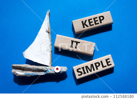 Keep it Simple symbol. Concept words Keep it Simple on wooden blocks. Beautiful blue background with boat. Business and Keep it Simple concept. Copy space. Keep it Simple symbol. Concept words Keep it Simple on wooden blocks. Beautiful blue background with boat. Business and Keep it Simple concept. Copy space. 112588180