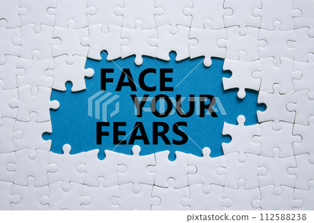 Face your Fears symbol. Concept words Face your Fears on white puzzle. Beautiful blue background. Business and Face your Fears. Copy space. 112588238