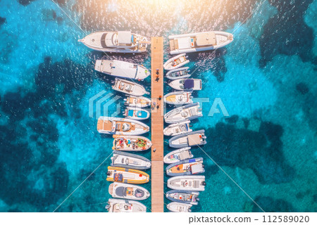 Aerial view of boats and luxure yachts in dock in summer day Aerial view of boats and luxure yachts in dock in summer day 112589020