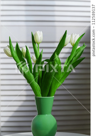 Bouquet of white tulips on a light background. Bouquet of white tulips on a light background. 112589137
