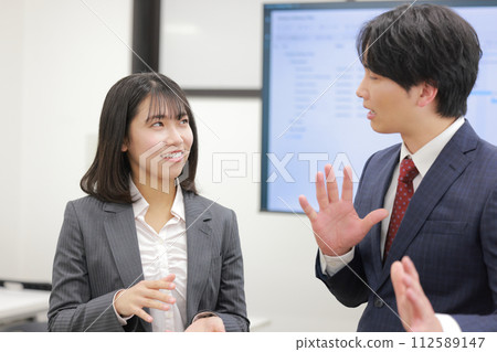 Standing meeting_A man who has an opposing opinion to a woman making a proposal_2 112589147